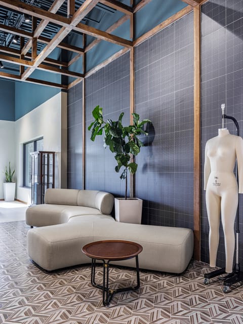 Curved lounge seating and planting against a dark tiled feature wall